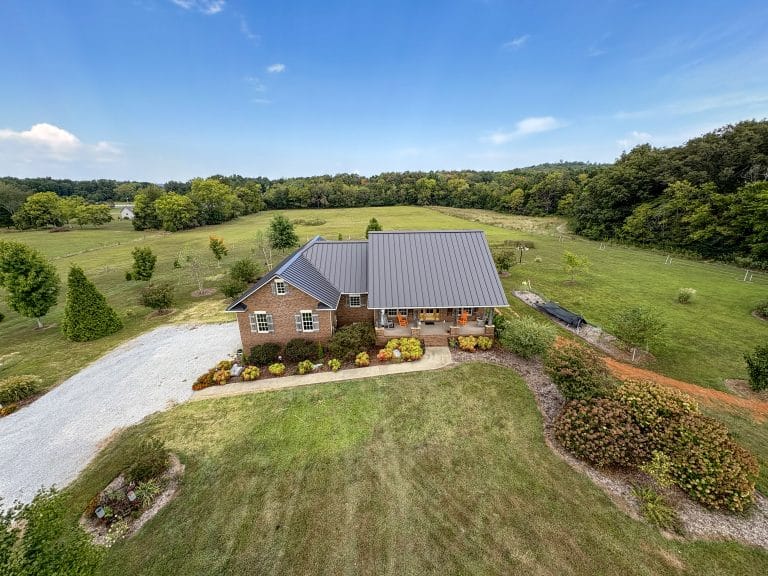Aerial view of a newly installed standing seam roof on a brick home.