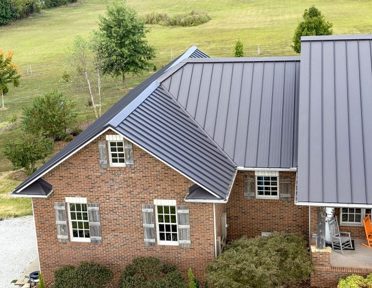 Drone image of a beautiful, dark grey standing seam roof installed on a residential home