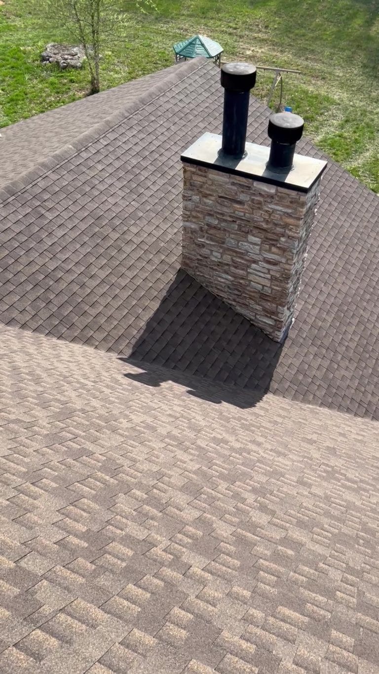 Newly installed shingle roof, with a chimney and a valley